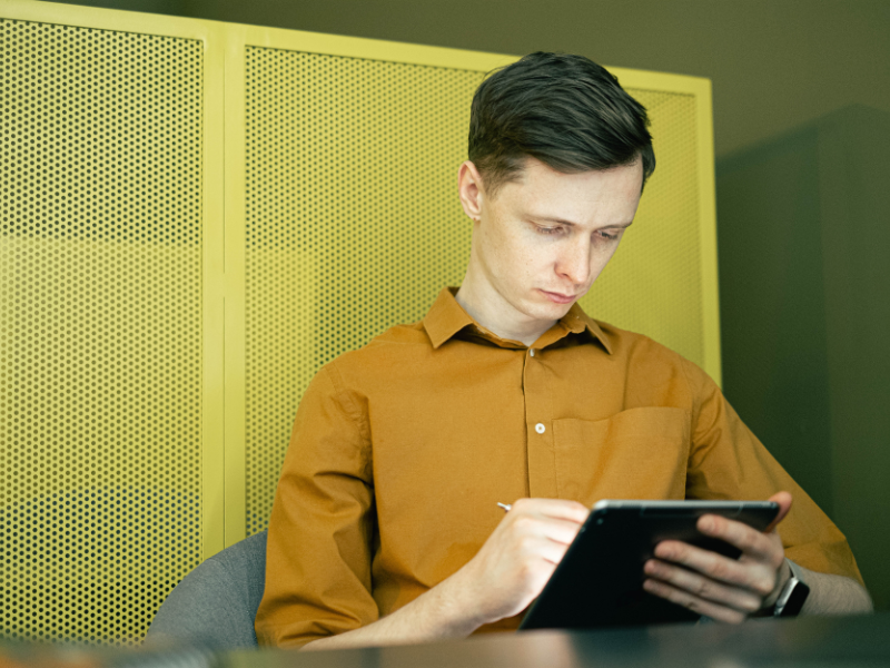A man looking at a tablet in an office
