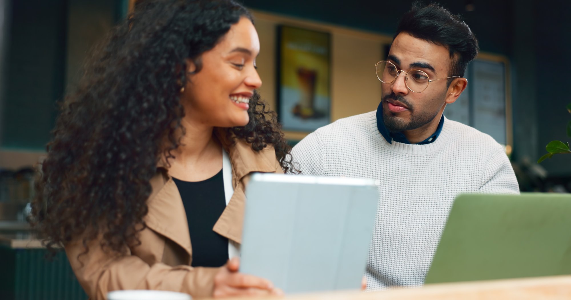 Coworkers smiling and in discussion over screens