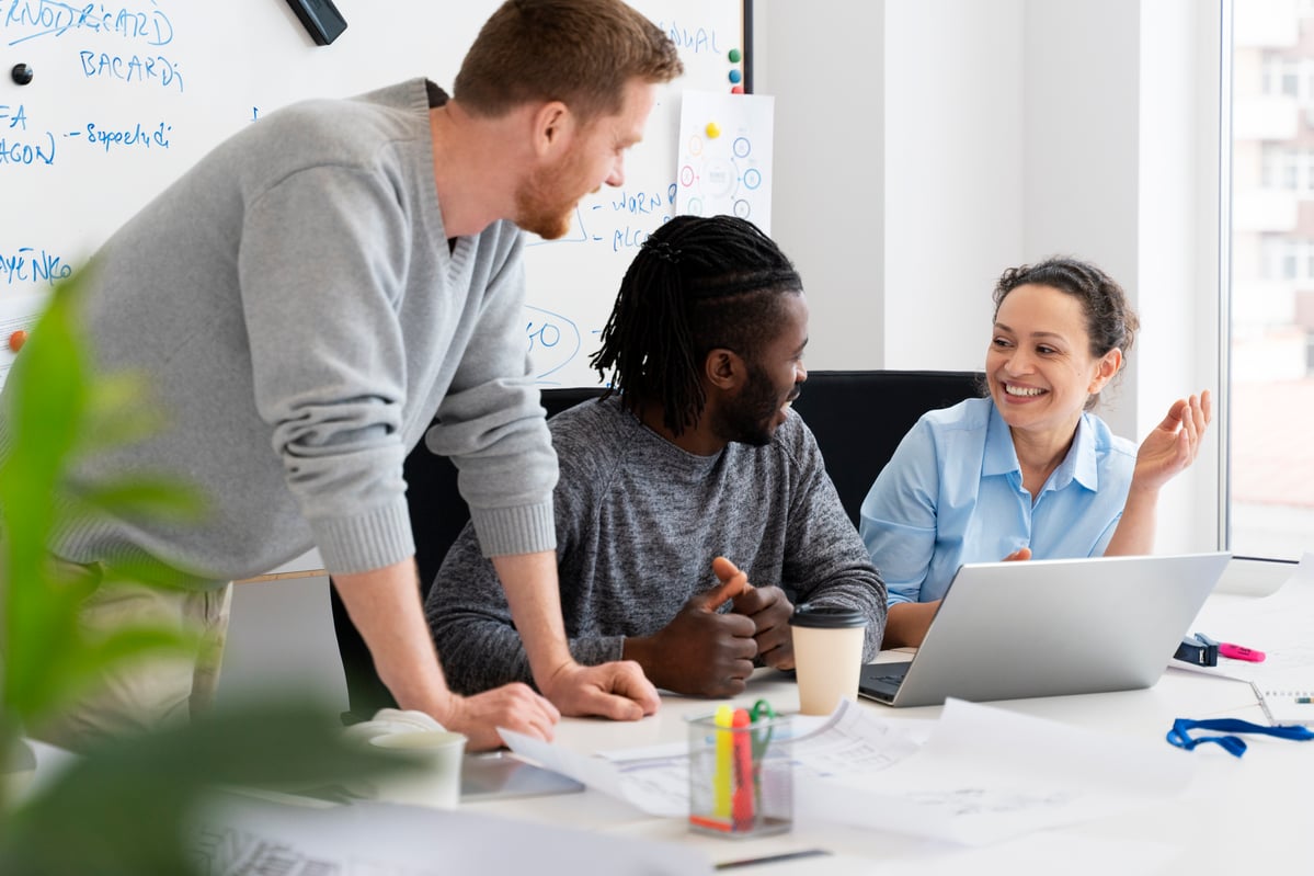 Image of colleagues talking over a laptop