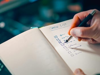 A person with notepad with a checklist open
